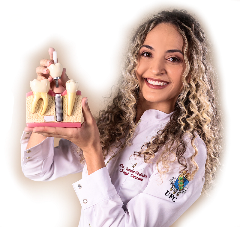 Dra. Nathalya Fedechen sorrindo, usando jaleco branco, representando seu trabalho como cirurgiã-dentista.